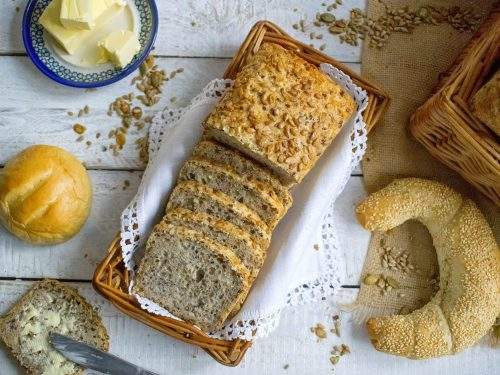 Na zdjęciu widać chleb pszenny na zakwasie, pokrojony w kromki i ułożony w koszyku. Widoczne są ziarna słonecznika, dyni i siemienia lnianego, którymi wzbogacony jest nasz pełnoziarnisty chleb,.